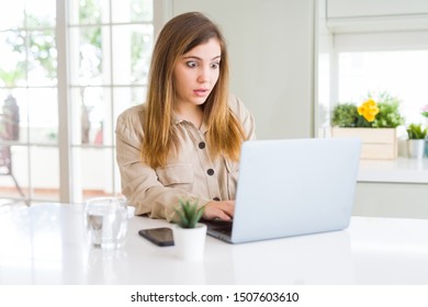 Beautiful Young Woman Using Computer Laptop Scared In Shock With A Surprise Face, Afraid And Excited With Fear Expression