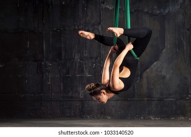 Beautiful young woman using hammock for doing pose of antigravity yoga - Powered by Shutterstock