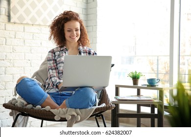 Beautiful young woman using laptop at home
