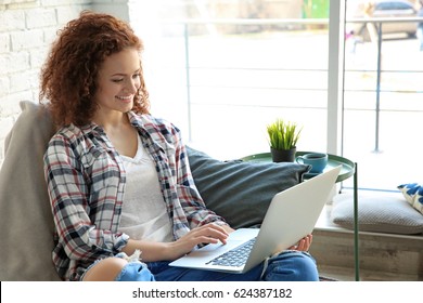 Schöne junge Frau mit Laptop zu Hause