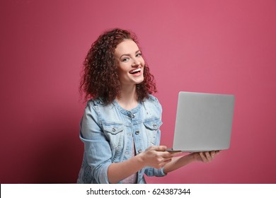 Beautiful Young Woman Using Laptop On Color Background