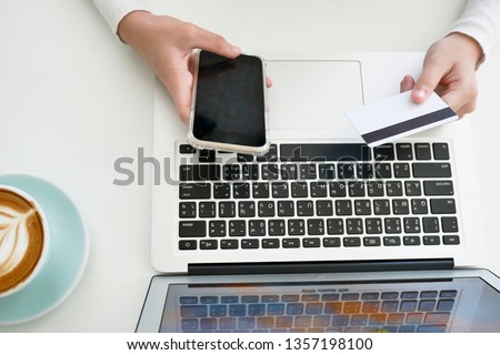 Beautiful young woman using portable laptop computer while . Young beautiful girl using a personal laptop computer to bill pay on the internet