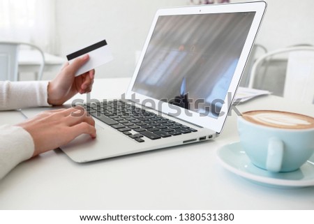 Beautiful young woman using portable laptop computer while . Young beautiful girl using a personal laptop computer to bill pay on the internet.