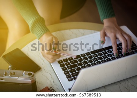 Beautiful young woman using portable laptop computer while sitting in the coffee shop. Young beautiful girl using a personal laptop computer to online bill pay on the internet.