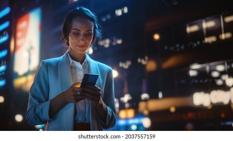 Beautiful Young Woman Using Smartphone Walking Through Night City Street Full Neon Light  Portrait Gorgeous Smiling Female Using Mobile Phone 