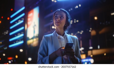 Beautiful Young Woman Using Smartphone Standing the Night City Street Full Neon Light  Portrait Gorgeous Smiling Female Using Mobile Phone 