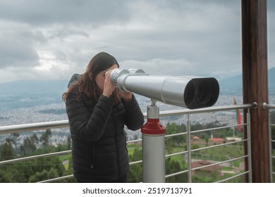 Beautiful young woman, at a viewing point, observing the landscape through long binoculars mounted on a metal pedestal against a cloudy sky background - Powered by Shutterstock