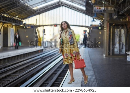 Beautiful young woman waiting for a train on the platform of Parisian underground