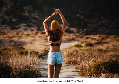 Beautiful Young Woman Walking Over A Wood Path