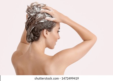 Beautiful Young Woman Washing Hair Against Light Color Background