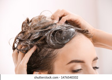 Beautiful young woman washing hair, closeup