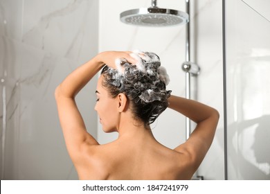 家でシャワーを浴びて髪を洗う美しい若い女性