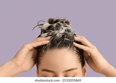 Beautiful young woman washing her hair with shampoo on purple background, closeup - Powered by Shutterstock