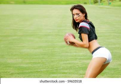 Beautiful Young Woman Wearing American Football Outfit Throwing Football