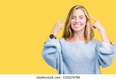 Beautiful young woman wearing blue sweater over isolated background Smiling pointing to head with both hands finger, great idea or thought, good memory