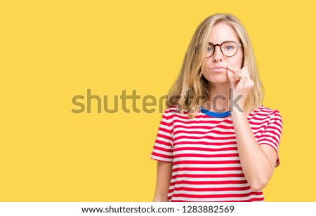 Beautiful young woman wearing glasses over isolated background mouth and lips shut as zip with fingers. Secret and silent, taboo talking