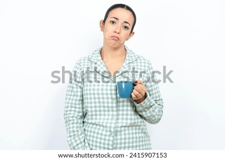 Beautiful young woman wearing green plaid pyjama depressed and worry for distress, crying angry and afraid. Sad expression.