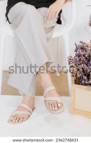Beautiful young woman wearing grey pant and beige shoue in studio. Modern style, summer fashion trend, footwear, sandals, fashionable accessories, perfect skin, noface.