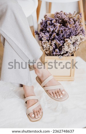 Beautiful young woman wearing grey pant and beige shoue in studio. Modern style, summer fashion trend, footwear, sandals, fashionable accessories, perfect skin, noface.