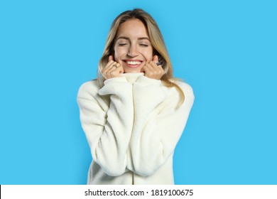 Beautiful young woman wearing knitted sweater on light blue background - Shutterstock ID 1819100675