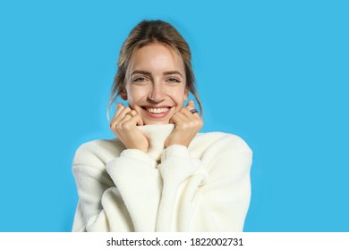 Beautiful young woman wearing knitted sweater on light blue background - Shutterstock ID 1822002731