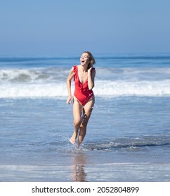 Beautiful Young Woman Wearing Red Swimsuit On The Beach Near Pacific Ocean