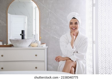 Beautiful young woman wearing soft white robe in bathroom - Powered by Shutterstock