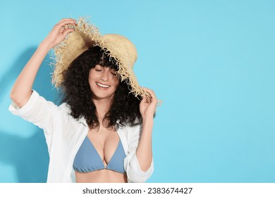 Beautiful young woman wearing straw hat on light blue background, space for text. Sun protection accessory - Powered by Shutterstock