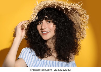 Beautiful young woman wearing straw hat in sunlight on orange background. Sun protection accessory - Powered by Shutterstock