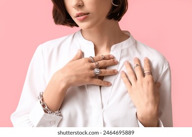 Beautiful young woman wearing stylish silver jewelry on pink background, closeup Foto Stok