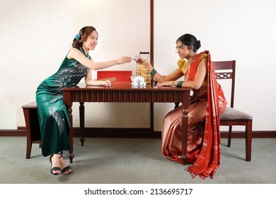 Beautiful young woman wearing traditional cultural dress of Malaysia malay Indian Chinese saree cheongsam talk pose retro vintage look table