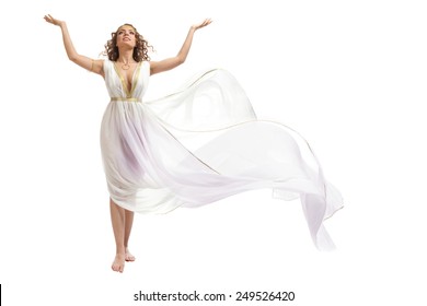 The Beautiful Young Woman Wearing White And Gold Greek Costume, Raising Her Arms On The White Background