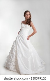 The Beautiful Young Woman In A Wedding Dress On A White Background.