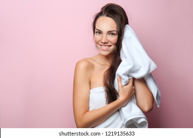 Beautiful young woman wiping hair with towel on color background - Powered by Shutterstock