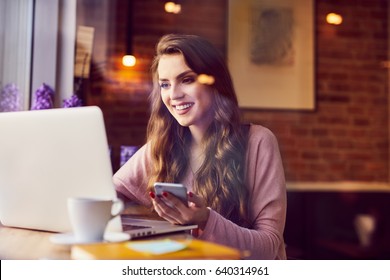 Beautiful Young Woman Working With Laptop From Coffee Shop