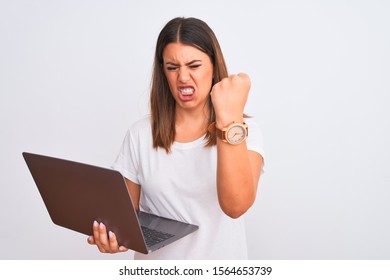 Beautiful Young Woman Working Using Computer Laptop Over White Background Angry And Mad Raising Fist Frustrated And Furious While Shouting With Anger. Rage And Aggressive Concept.