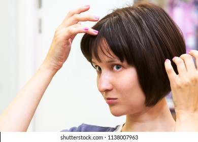 Beautiful Young Woman Is Worried About Her First Grey Hair.