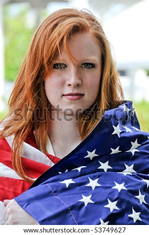 A beautiful young woman wrapped in a flag.