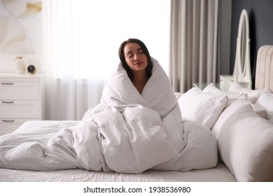 Beautiful Young Woman Wrapped With Soft Blanket On Bed At Home