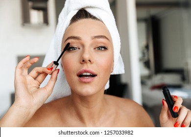 Beautiful Young Woman Wrapped In A Towel Doing Her Eye Makeup