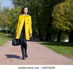 Beautiful Young Woman In Yellow Coat In Autumn Street