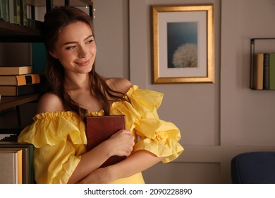 Beautiful Young Woman In Yellow Dress With Book Near Home Library Indoors