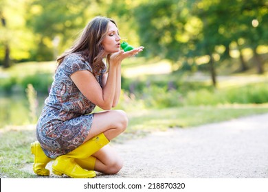 Beautiful Young Woman In Yellow Rain Boots With Rubber Toy Frog. Outdoors. Fairytale Concept