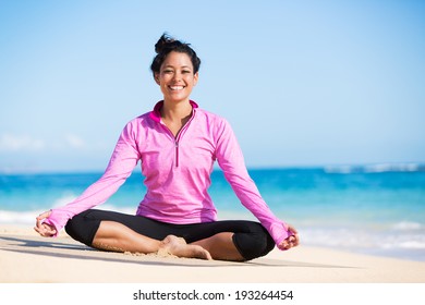 Beautiful young woman in yoga pose at the beach. Morning zen mediation outdoors. Practicing yoga. Healthy lifestyle.