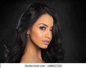 Beautiful young woman's face with gorgeous curly black hair
