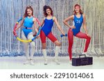 Beautiful young women in blue and red sportswear training fit fitness equipments, doing stretching and aerobics exercises. Concept of retro fitness, sport, 80s fashion, beauty, health