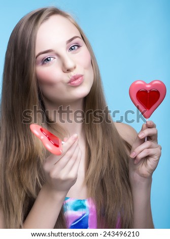 beautiful young women with lollipops in the shape of a heart