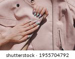 Beautiful youth manicure. The design is a mix of pink and blue. Unicorn color varnish. Gel polish nail polish. Spring fresh trend summer. Flatlay. Phalanx ring. Leather jacket young look close up