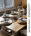 
Beautifully arranged autumn table setting with rustic decor featuring pumpkins, candles, and natural elements, perfect for a festive Thanksgiving meal or family celebration in a cozy dining room.