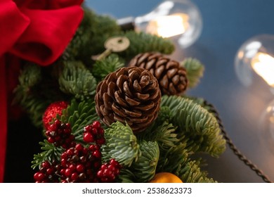 A beautifully arranged Christmas wreath features fragrant cinnamon sticks, pinecones, and colorful ornaments, illuminated by soft, warm lights. Danish spruce wreath. - Powered by Shutterstock